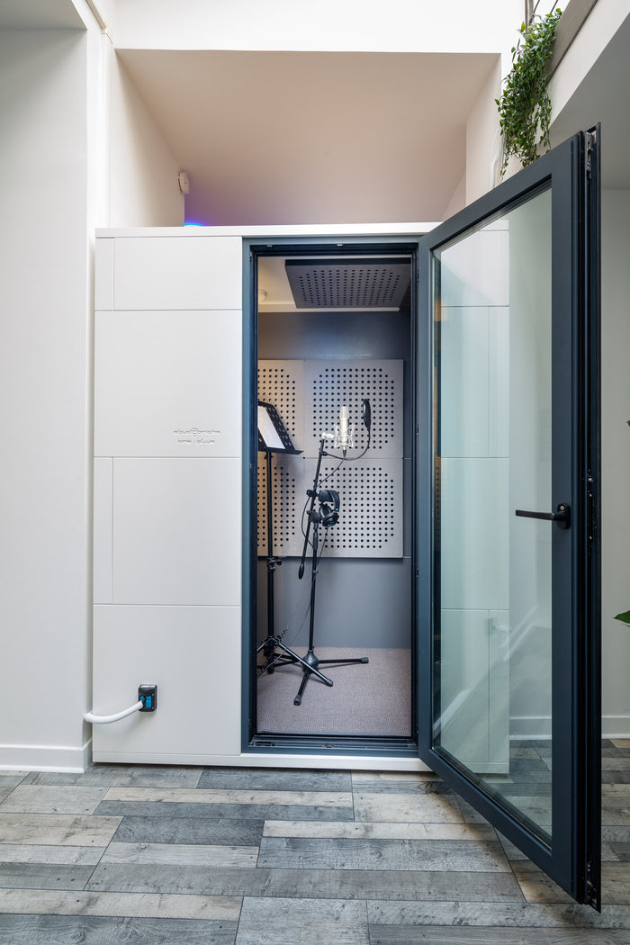 Cabine de prise de voix du studio&nbsp;B d'Hedayat Music, porte vitrée ouverte sur un micro sur pied
